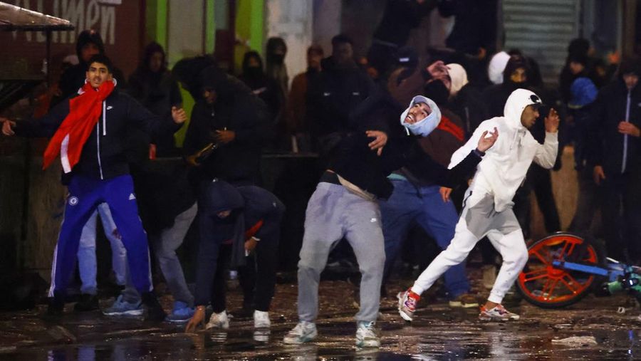 Seorang pria dengan wajah tertutup dan alat pemadam api terlihat selama bentrokan usai pertandingan Piala Dunia antara Belgia dan Maroko di Brussel, Belgia, Minggu (27/11/2022). Bentrokan terjadi di Kota Brussel usai Timnas Belgia kalah dari Maroko 2-0 di Piala Dunia Qatar. Para suporter menyalakan api dan melemparkan petasan ke polisi. (REUTERS/Yves Herman)