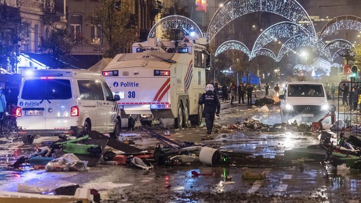 Bentrokan Suporter dengan Polisi di Brussel, Belgia Usai Pertandingan piala dunia antara Belgia dan Maroko Mobil polisi melewati sisa-sisa bentrokan usai pertandingan Piala Dunia antara Belgia dan Maroko di Brussel, Belgia, Minggu (27/11/2022). Bentrokan terjadi di Kota Brussel usai Timnas Belgia kalah dari Maroko 2-0 di Piala Dunia Qatar. Para suporter menyalakan api dan melemparkan petasan ke polisi. (AP Photo/Geert Vanden Wijngaert)