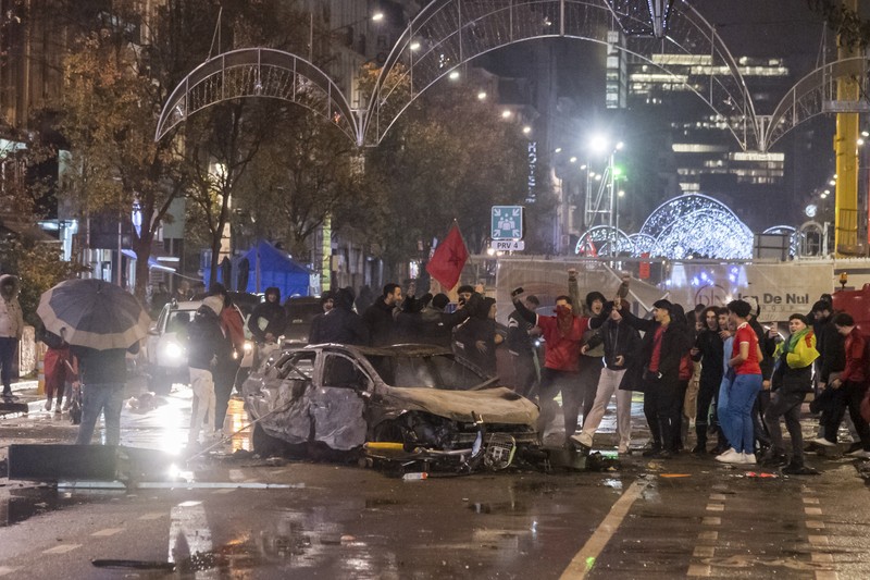 Bentrokan Suporter dengan Polisi di Brussel, Belgia Usai Pertandingan piala dunia antara Belgia dan Maroko Seorang pria dengan wajah tertutup dan alat pemadam api terlihat selama bentrokan usai pertandingan Piala Dunia antara Belgia dan Maroko di Brussel, Belgia, Minggu (27/11/2022). Bentrokan terjadi di Kota Brussel usai Timnas Belgia kalah dari Maroko 2-0 di Piala Dunia Qatar. Para suporter menyalakan api dan melemparkan petasan ke polisi. (REUTERS/Yves Herman)