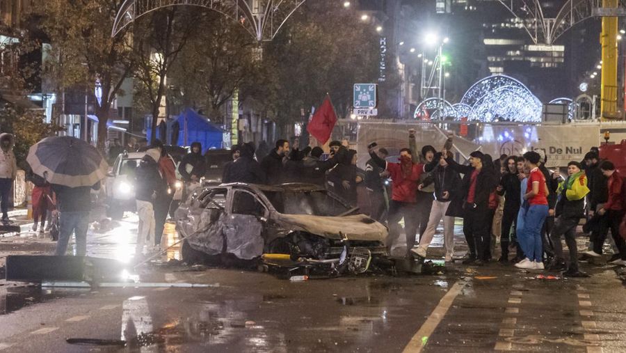 Seorang pria dengan wajah tertutup dan alat pemadam api terlihat selama bentrokan usai pertandingan Piala Dunia antara Belgia dan Maroko di Brussel, Belgia, Minggu (27/11/2022). Bentrokan terjadi di Kota Brussel usai Timnas Belgia kalah dari Maroko 2-0 di Piala Dunia Qatar. Para suporter menyalakan api dan melemparkan petasan ke polisi. (REUTERS/Yves Herman)
