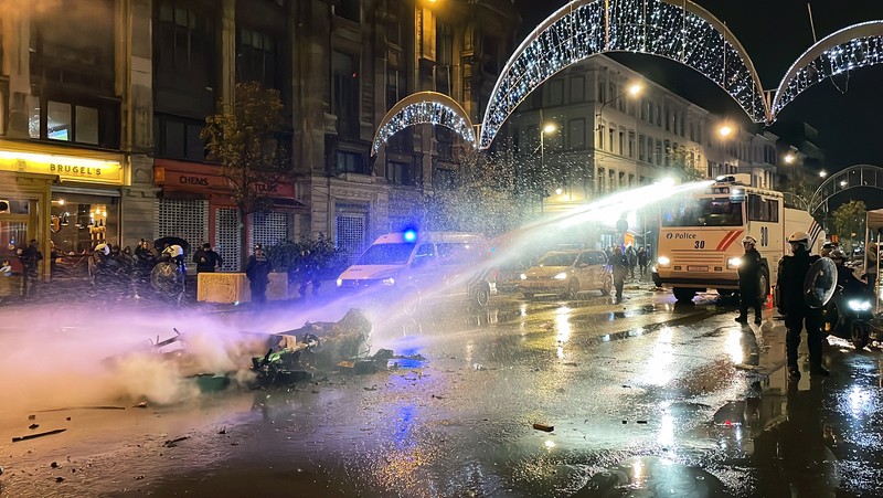 Seorang pria dengan wajah tertutup dan alat pemadam api terlihat selama bentrokan usai pertandingan Piala Dunia antara Belgia dan Maroko di Brussel, Belgia, Minggu (27/11/2022). Bentrokan terjadi di Kota Brussel usai Timnas Belgia kalah dari Maroko 2-0 di Piala Dunia Qatar. Para suporter menyalakan api dan melemparkan petasan ke polisi. (REUTERS/Yves Herman)