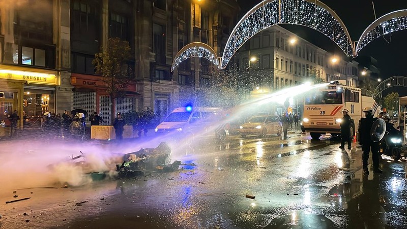 Seorang pria dengan wajah tertutup dan alat pemadam api terlihat selama bentrokan usai pertandingan Piala Dunia antara Belgia dan Maroko di Brussel, Belgia, Minggu (27/11/2022). Bentrokan terjadi di Kota Brussel usai Timnas Belgia kalah dari Maroko 2-0 di Piala Dunia Qatar. Para suporter menyalakan api dan melemparkan petasan ke polisi. (REUTERS/Yves Herman)