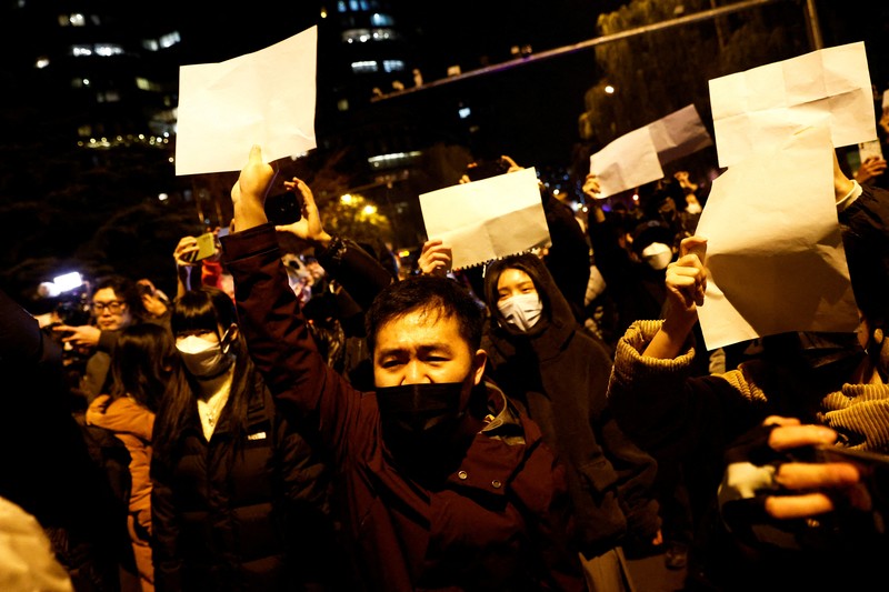 Demo pembatasan penyakit coronavirus (COVID-19) di China Para pengunjuk rasa mengangkat selembar kertas putih menentang pembatasan gerak akibat penyebaran virus corona (COVID-19) di Beijing, Sabtu (27/11/2022). Protes tersebut terjadi usai kebakaran yang terjadi pada 24 November 2022 di Urumqi, ibu kota wilayah Xinjiang China barat laut yang menimbukan kemarahan publik yang menyalahkan penguncian akibat virus corona karena menghambat upaya penyelamatan. Aksi demo di China termasuk kejadian yang cukup langka, yang belum pernah terjadi sebelumnya sejak Xi Jinping mengambil alih kekuasaan satu dekade lalu. (Photo by Kevin Frayer/Getty Images)