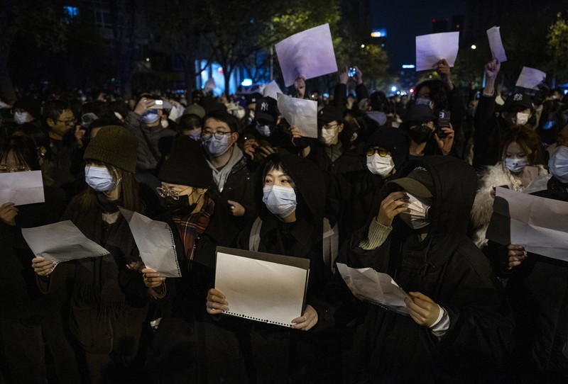 Demo pembatasan penyakit coronavirus (COVID-19) di China Para pengunjuk rasa mengangkat selembar kertas putih menentang pembatasan gerak akibat penyebaran virus corona (COVID-19) di Beijing, Sabtu (27/11/2022). Protes tersebut terjadi usai kebakaran yang terjadi pada 24 November 2022 di Urumqi, ibu kota wilayah Xinjiang China barat laut yang menimbukan kemarahan publik yang menyalahkan penguncian akibat virus corona karena menghambat upaya penyelamatan. Aksi demo di China termasuk kejadian yang cukup langka, yang belum pernah terjadi sebelumnya sejak Xi Jinping mengambil alih kekuasaan satu dekade lalu. (Photo by Kevin Frayer/Getty Images)