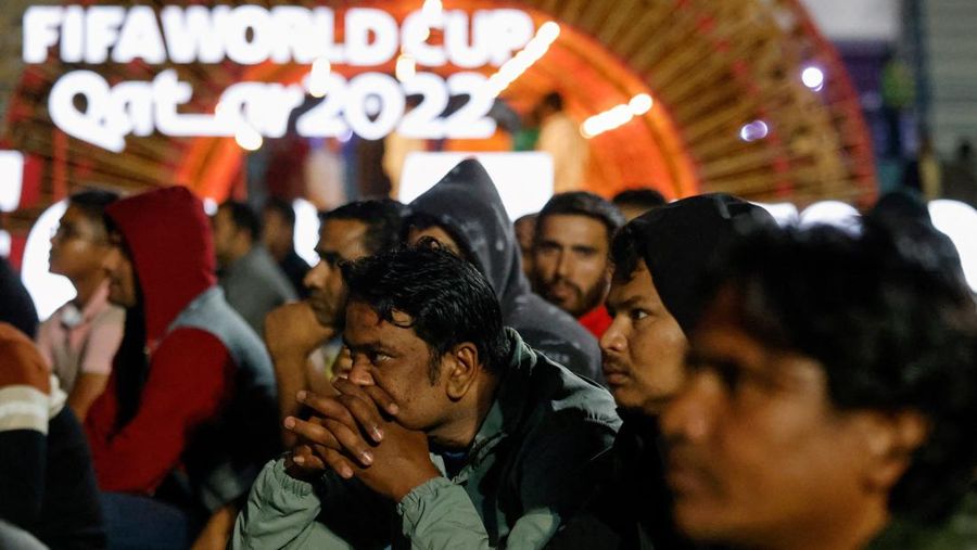 Qatar's migrant workers watch the Qatar 2022 World Cup Group E football match between Spain and Germany on November 27, 2022, at the Asian Town cricket stadium, on the outskirts of Doha. - The stadium has become a daily draw for thousands of the poorest workers who live in nearby dormitories away from Doha's glitzy shopping malls and restaurants. (Photo by David GANNON / AFP) (Photo by DAVID GANNON/AFP via Getty Images)