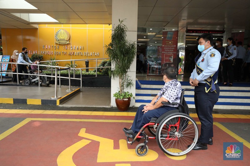 Petugas melayani warga berkebutuhan khusus  (disabilitas) dalam acara Pembukaan Pekan Layanan Keimigrasian Ramah HAM dalam rangka Peringatan Hari HAM Sedunia ke-74 Tahun 2022 di Kantor Imigrasi Kelas I Khusus Non TPI, Jakarta, Senin (28/11/2022). (CNBC Indonesia/Tri Susilo)