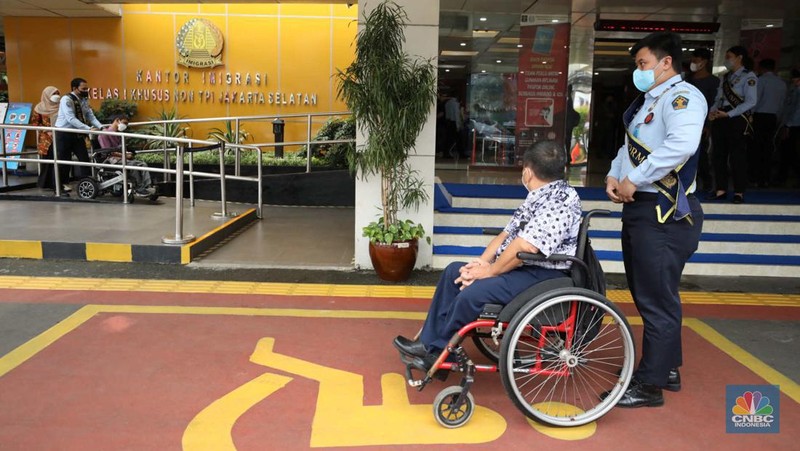 Petugas melayani warga berkebutuhan khusus  (disabilitas) dalam acara Pembukaan Pekan Layanan Keimigrasian Ramah HAM dalam rangka Peringatan Hari HAM Sedunia ke-74 Tahun 2022 di Kantor Imigrasi Kelas I Khusus Non TPI, Jakarta, Senin (28/11/2022). (CNBC Indonesia/Tri Susilo)