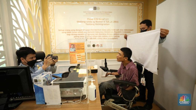 Petugas melayani warga berkebutuhan khusus  (disabilitas) dalam acara Pembukaan Pekan Layanan Keimigrasian Ramah HAM dalam rangka Peringatan Hari HAM Sedunia ke-74 Tahun 2022 di Kantor Imigrasi Kelas I Khusus Non TPI, Jakarta, Senin (28/11/2022). (CNBC Indonesia/Tri Susilo)