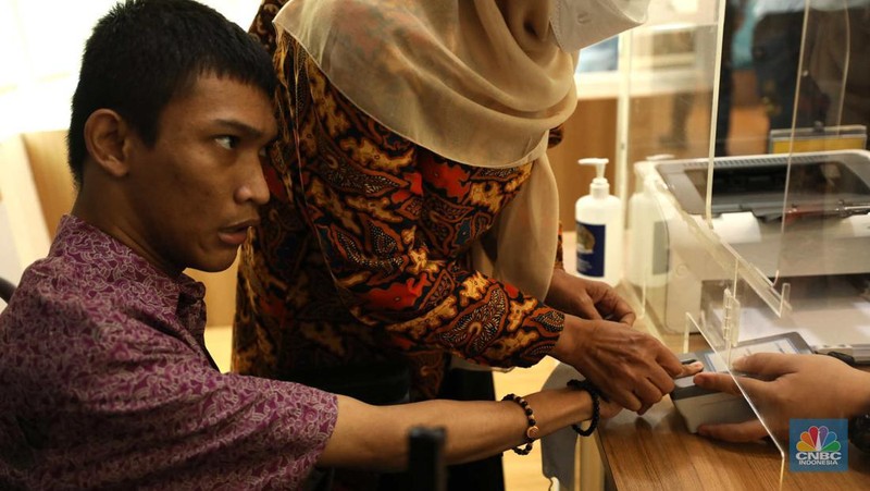 Petugas melayani warga berkebutuhan khusus  (disabilitas) dalam acara Pembukaan Pekan Layanan Keimigrasian Ramah HAM dalam rangka Peringatan Hari HAM Sedunia ke-74 Tahun 2022 di Kantor Imigrasi Kelas I Khusus Non TPI, Jakarta, Senin (28/11/2022). (CNBC Indonesia/Tri Susilo)