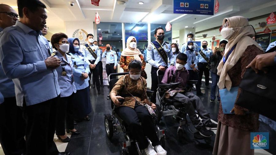 Petugas melayani warga berkebutuhan khusus  (disabilitas) dalam acara Pembukaan Pekan Layanan Keimigrasian Ramah HAM dalam rangka Peringatan Hari HAM Sedunia ke-74 Tahun 2022 di Kantor Imigrasi Kelas I Khusus Non TPI, Jakarta, Senin (28/11/2022). (CNBC Indonesia/Tri Susilo)