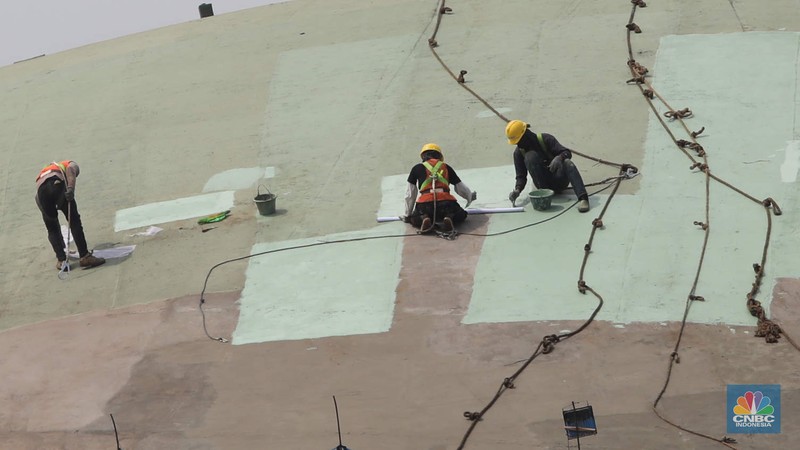 Pekerja menyelesaikan renovasi atap Gedung Nusantara DPR atau yang lebih dikenal dengan nama Gedung Kura-kura di kompleks Parlemen, Jakarta, Senin (28/11/2022). Sekretariat Jenderal DPR menganggarkan Rp4,5 miliar untuk perbaikan gedung tersebut. (CNBC Indonesia/ Muhammad Sabki)