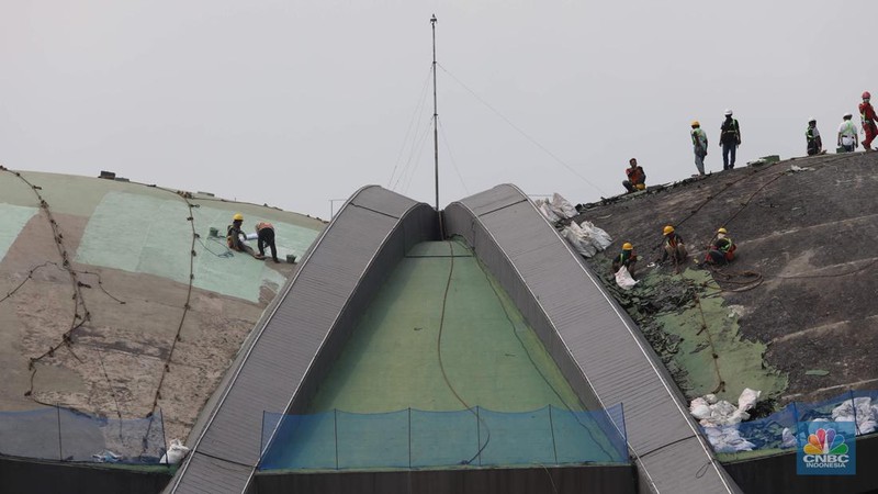 Pekerja menyelesaikan renovasi atap Gedung Nusantara DPR atau yang lebih dikenal dengan nama Gedung Kura-kura di kompleks Parlemen, Jakarta, Senin (28/11/2022). Sekretariat Jenderal DPR menganggarkan Rp4,5 miliar untuk perbaikan gedung tersebut. (CNBC Indonesia/ Muhammad Sabki)