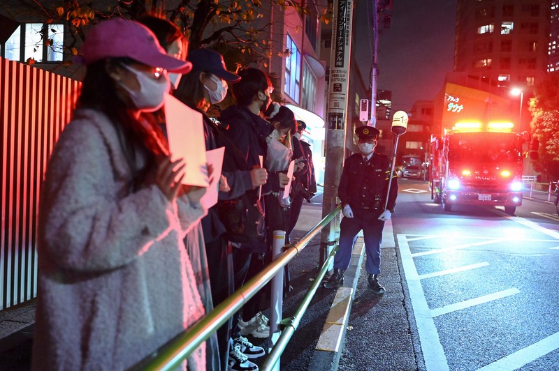 A group of protesters hold a peaceful gathering down the street from the Chinese embassy in Tokyo on November 28, 2022, in support of demonstrations held in China over Beijing's Covid-19 restrictions. - Hundreds of people have taken to the streets in China's major cities in a rare outpouring of public anger against the state over its zero-Covid policy. (Photo by Richard A. Brooks / AFP) (Photo by RICHARD A. BROOKS/AFP via Getty Images)