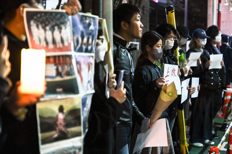 Sekelompok pengunjuk rasa mengadakan pertemuan damai di jalan dari kedutaan besar China di Tokyo pada 28 November 2022, untuk mendukung demonstrasi yang diadakan di China atas pembatasan Covid-19 Beijing. A group of protesters hold a peaceful gathering down the street from the Chinese embassy in Tokyo on November 28, 2022, in support of demonstrations held in China over Beijing's Covid-19 restrictions. - Hundreds of people have taken to the streets in China's major cities in a rare outpouring of public anger against the state over its zero-Covid policy. (Photo by Richard A. Brooks / AFP) (Photo by RICHARD A. BROOKS/AFP via Getty Images)
