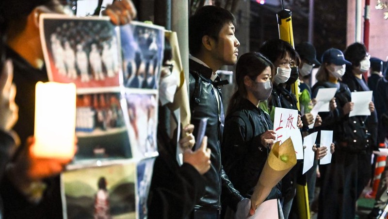 A group of protesters hold a peaceful gathering down the street from the Chinese embassy in Tokyo on November 28, 2022, in support of demonstrations held in China over Beijing's Covid-19 restrictions. - Hundreds of people have taken to the streets in China's major cities in a rare outpouring of public anger against the state over its zero-Covid policy. (Photo by Richard A. Brooks / AFP) (Photo by RICHARD A. BROOKS/AFP via Getty Images)