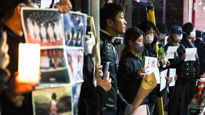 Sekelompok pengunjuk rasa mengadakan pertemuan damai di jalan dari kedutaan besar China di Tokyo pada 28 November 2022, untuk mendukung demonstrasi yang diadakan di China atas pembatasan Covid-19 Beijing. A group of protesters hold a peaceful gathering down the street from the Chinese embassy in Tokyo on November 28, 2022, in support of demonstrations held in China over Beijing's Covid-19 restrictions. - Hundreds of people have taken to the streets in China's major cities in a rare outpouring of public anger against the state over its zero-Covid policy. (Photo by Richard A. Brooks / AFP) (Photo by RICHARD A. BROOKS/AFP via Getty Images)