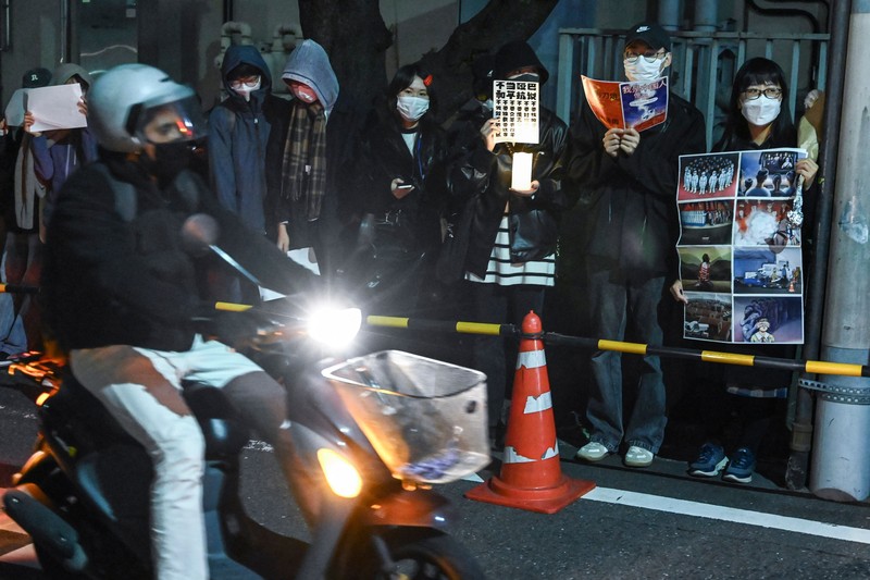 Sekelompok pengunjuk rasa mengadakan pertemuan damai di jalan dari kedutaan besar China di Tokyo pada 28 November 2022, untuk mendukung demonstrasi yang diadakan di China atas pembatasan Covid-19 Beijing. A group of protesters hold a peaceful gathering down the street from the Chinese embassy in Tokyo on November 28, 2022, in support of demonstrations held in China over Beijing's Covid-19 restrictions. - Hundreds of people have taken to the streets in China's major cities in a rare outpouring of public anger against the state over its zero-Covid policy. (Photo by Richard A. Brooks / AFP) (Photo by RICHARD A. BROOKS/AFP via Getty Images)