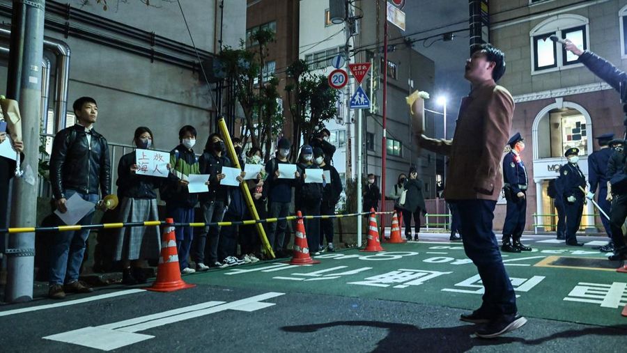 A group of protesters hold a peaceful gathering down the street from the Chinese embassy in Tokyo on November 28, 2022, in support of demonstrations held in China over Beijing's Covid-19 restrictions. - Hundreds of people have taken to the streets in China's major cities in a rare outpouring of public anger against the state over its zero-Covid policy. (Photo by Richard A. Brooks / AFP) (Photo by RICHARD A. BROOKS/AFP via Getty Images)