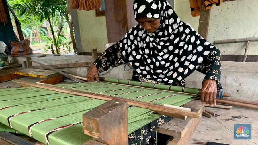 Seorang pengrajin menyelesaikan pengerjaan tenun kain ikat Gunung Mako di Sebanjar, Desa Ternate, Alor Barat Laut, Alor, Nusa Tenggara Timur. (CNBC Indonesia/ Maikel Jefriando)