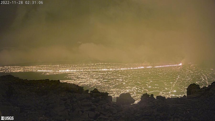 Foto yang diambil dari area Rekreasi Gilbert Kahele di Maunakea memperlihatkan Lava menyembur keluar dari kawah puncak Mauna Loa sekitar pukul 06.35 di Hawaii, Senin (28/11/2022). Mauna Loa, gunung berapi aktif terbesar di dunia yang berada di negara bagian Hawaii, Amerika Serikat (AS), meletus untuk pertama kalinya dalam hampir 40 tahun. (Chelsea Jensen/West Hawaii Today via AP)