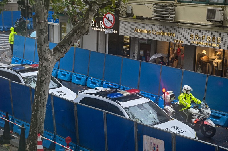 Kendaraan polisi terlihat di sebelah jalan Wulumuqi, dinamai Urumqi dalam bahasa Mandarin, di Shanghai pada 29 November 2022, dua hari setelah protes yang jarang terjadi terhadap kebijakan nol-Covid China menyusul kebakaran mematikan di Urumqi, ibu kota wilayah Xinjiang. Kendaraan polisi terlihat di sebelah jalan Wulumuqi, dinamai Urumqi dalam bahasa Mandarin, di Shanghai pada 29 November 2022, dua hari setelah protes yang jarang terjadi terhadap kebijakan nol-Covid China menyusul kebakaran mematikan di Urumqi, ibu kota wilayah Xinjiang. (HECTOR RETAMAL/AFP melalui Getty Images)