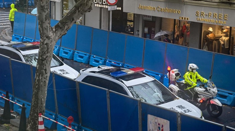 Kendaraan polisi terlihat di sebelah jalan Wulumuqi, dinamai Urumqi dalam bahasa Mandarin, di Shanghai pada 29 November 2022, dua hari setelah protes yang jarang terjadi terhadap kebijakan nol-Covid China menyusul kebakaran mematikan di Urumqi, ibu kota wilayah Xinjiang. (HECTOR RETAMAL/AFP melalui Getty Images)