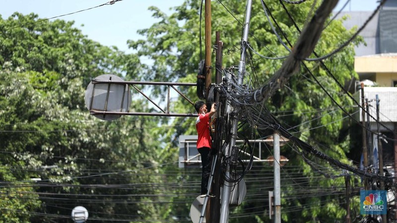 Sejumlah karyawan melewati jembatan penyeberangan orang (JPO) di kawasan Sudirman, Jakarta, Selasa (29/11/2022). Kepala Disnakertrans provinsi DKI Jakarta Andri Yansyah mengungkapkan kenaikan UMP 2023 DKI Jakarta sebesar 5,6% ke Rp 4.901.798.  (CNBC Indonesia/Tri Susilo)