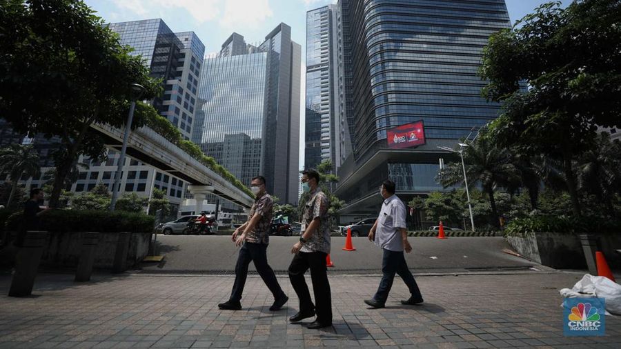 Sejumlah karyawan melewati jembatan penyeberangan orang (JPO) di kawasan Sudirman, Jakarta, Selasa (29/11/2022). Kepala Disnakertrans provinsi DKI Jakarta Andri Yansyah mengungkapkan kenaikan UMP 2023 DKI Jakarta sebesar 5,6% ke Rp 4.901.798.  (CNBC Indonesia/Tri Susilo)
