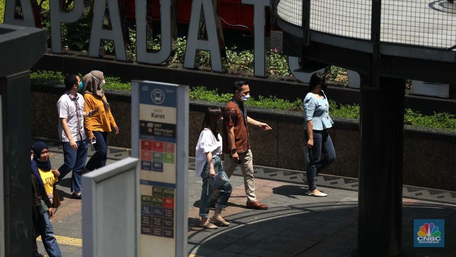 Sejumlah karyawan melewati jembatan penyeberangan orang (JPO) di kawasan Sudirman, Jakarta, Selasa (29/11/2022). Kepala Disnakertrans provinsi DKI Jakarta Andri Yansyah mengungkapkan kenaikan UMP 2023 DKI Jakarta sebesar 5,6% ke Rp 4.901.798.  (CNBC Indonesia/Tri Susilo)
