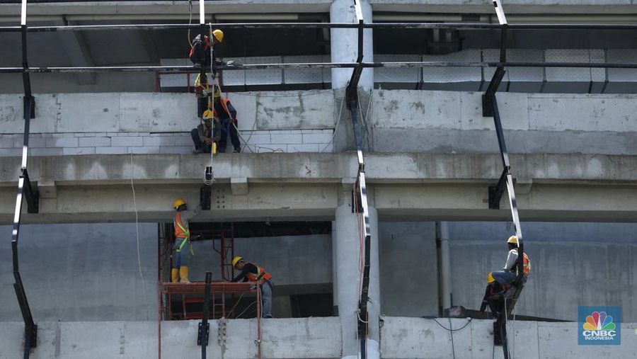 Sejumlah karyawan melewati jembatan penyeberangan orang (JPO) di kawasan Sudirman, Jakarta, Selasa (29/11/2022). Kepala Disnakertrans provinsi DKI Jakarta Andri Yansyah mengungkapkan kenaikan UMP 2023 DKI Jakarta sebesar 5,6% ke Rp 4.901.798.  (CNBC Indonesia/Tri Susilo)
