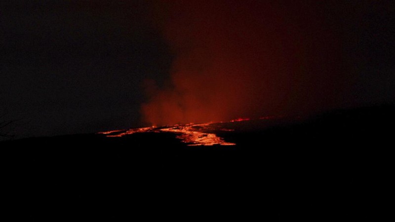 Foto yang diambil dari area Rekreasi Gilbert Kahele di Maunakea memperlihatkan Lava menyembur keluar dari kawah puncak Mauna Loa sekitar pukul 06.35 di Hawaii, Senin (28/11/2022). Mauna Loa, gunung berapi aktif terbesar di dunia yang berada di negara bagian Hawaii, Amerika Serikat (AS), meletus untuk pertama kalinya dalam hampir 40 tahun. (Chelsea Jensen/West Hawaii Today via AP)