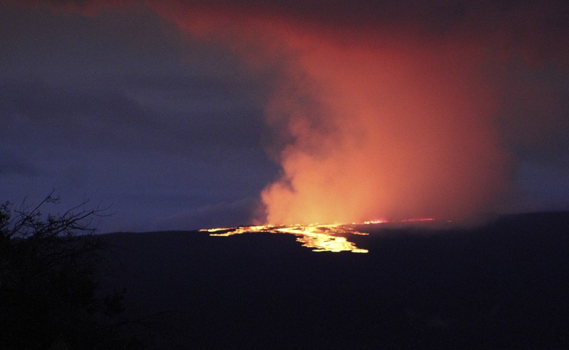 Mauna Loa, gunung berapi aktif terbesar di dunia meletus di hawaii Foto yang diambil dari area Rekreasi Gilbert Kahele di Maunakea memperlihatkan Lava menyembur keluar dari kawah puncak Mauna Loa sekitar pukul 06.35 di Hawaii, Senin (28/11/2022). Mauna Loa, gunung berapi aktif terbesar di dunia yang berada di negara bagian Hawaii, Amerika Serikat (AS), meletus untuk pertama kalinya dalam hampir 40 tahun. (Chelsea Jensen/West Hawaii Today via AP)