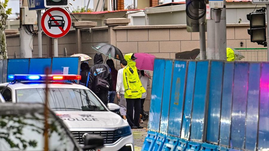 Kendaraan polisi terlihat di sebelah jalan Wulumuqi, dinamai Urumqi dalam bahasa Mandarin, di Shanghai pada 29 November 2022, dua hari setelah protes yang jarang terjadi terhadap kebijakan nol-Covid China menyusul kebakaran mematikan di Urumqi, ibu kota wilayah Xinjiang. (HECTOR RETAMAL/AFP melalui Getty Images)