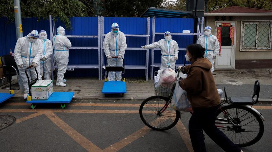 Seorang wanita mengantarkan makanan ke kompleks perumahan yang dikunci karena wabah penyakit virus corona (COVID-19) berlanjut di Beijing, China, Senin (28/11/2022). Kota-kota di Cina semakin banyak yang memberlakukan lockdown lokal menyusul naiknya kasus harian positif Covid-19. Komisi Kesehatan Nasional China melaporkan pada Senin (28/11) waktu setempat bahwa sedikitnya 40.052 kasus Corona tercatat dalam sehari, secara nasional di negara tersebut. (REUTERS/Thomas Peter)