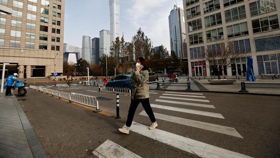 Seorang wanita mengantarkan makanan ke kompleks perumahan yang dikunci karena wabah penyakit virus corona (COVID-19) berlanjut di Beijing, China, Senin (28/11/2022). Kota-kota di Cina semakin banyak yang memberlakukan lockdown lokal menyusul naiknya kasus harian positif Covid-19. Komisi Kesehatan Nasional China melaporkan pada Senin (28/11) waktu setempat bahwa sedikitnya 40.052 kasus Corona tercatat dalam sehari, secara nasional di negara tersebut. (REUTERS/Thomas Peter)