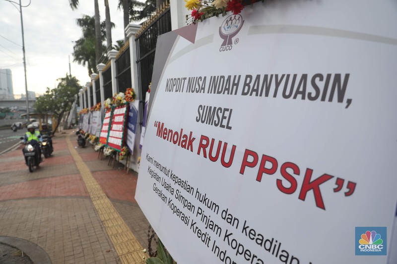 karangan bunga berisi penolakan rancangan undang-undang (RUU) penguatan, pengembangan sektor keuangan (PPSK) berjejer di depan gedung DPR/MPR Sejumlah karangan bunga berisi penolakan rancangan undang-undang (RUU) penguatan, pengembangan sektor keuangan (PPSK) berjejer di depan gedung DPR/MPR, Jakarta, Rabu (30/11/2022). Puluhan karangan bunga berisi penolakan rancangan undang-undang (RUU) penguatan, pengembangan sektor keuangan (PPSK) memenuhi pagar depan gedung Dewan Perwakilan Rakyat Republik Indonesia (DPR RI). (CNBC Indonesia/ Muhammad Sabki)