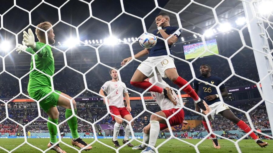 Penyerang Prancis, Kylian Mbappe mencetak gol kedua timnya usai melewati kiper Denmark, Kasper Schmeichel saat pertandingan Group D antara Prancis melawan Denmark pada laga Piala Dunia FIFA Qatar 2022 di Stadion 974, Doha, Qatar, Sabtu (26/11/2022). Prancis jadi tim pertama yang lolos ke Babak 16 Besar Piala Dunia 2022 setelah Les Bleus mengalahkan Denmark 2-1 berkat sepasang gol Kylian Mbappe. (Photo by FRANCK FIFE/AFP via Getty Images)