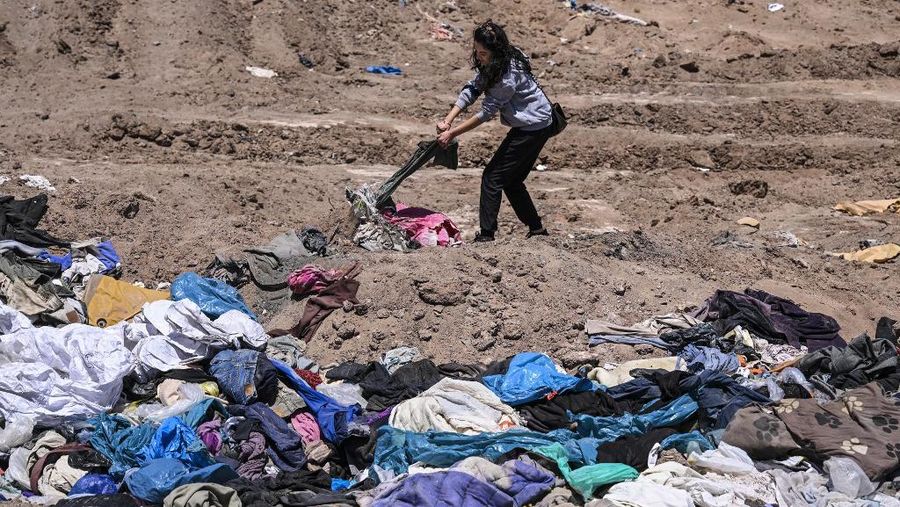 Pengacara Paulina Silva menunjukkan pakaian yang dibuang di padang pasir, di sektor La Pampa di Alto Hospicio, Gurun Atacama, Chili, Sabtu (12/11/2022). Gurun Atacama yang juga merupakan lokasi penelitian ilmiah untuk hidup di Mars merupakan daerah terkering di Bumi terancam oleh tumpukan sampah yang dibuang ke sana dari seluruh dunia. Setiap tahunnya ada lebih dari 46.000 ton sampah dikirim ke gurun pasir yang ada di antara Andes dan rangkaian pengunungan Chili. (Photo by MARTIN BERNETTI / AFP)