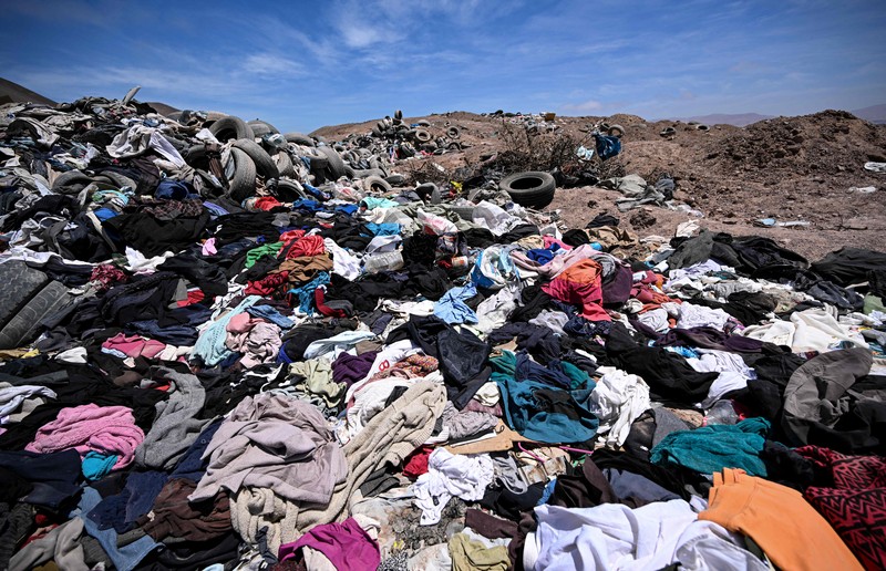Gurun Atacama di Chili merupakan daerah terkering di Bumi yang juga merupakan lokasi penelitian ilmiah untuk hidup di Mars Pengacara Paulina Silva menunjukkan pakaian yang dibuang di padang pasir, di sektor La Pampa di Alto Hospicio, Gurun Atacama, Chili, Sabtu (12/11/2022). Gurun Atacama yang juga merupakan lokasi penelitian ilmiah untuk hidup di Mars merupakan daerah terkering di Bumi terancam oleh tumpukan sampah yang dibuang ke sana dari seluruh dunia. Setiap tahunnya ada lebih dari 46.000 ton sampah dikirim ke gurun pasir yang ada di antara Andes dan rangkaian pengunungan Chili. (Photo by MARTIN BERNETTI / AFP)