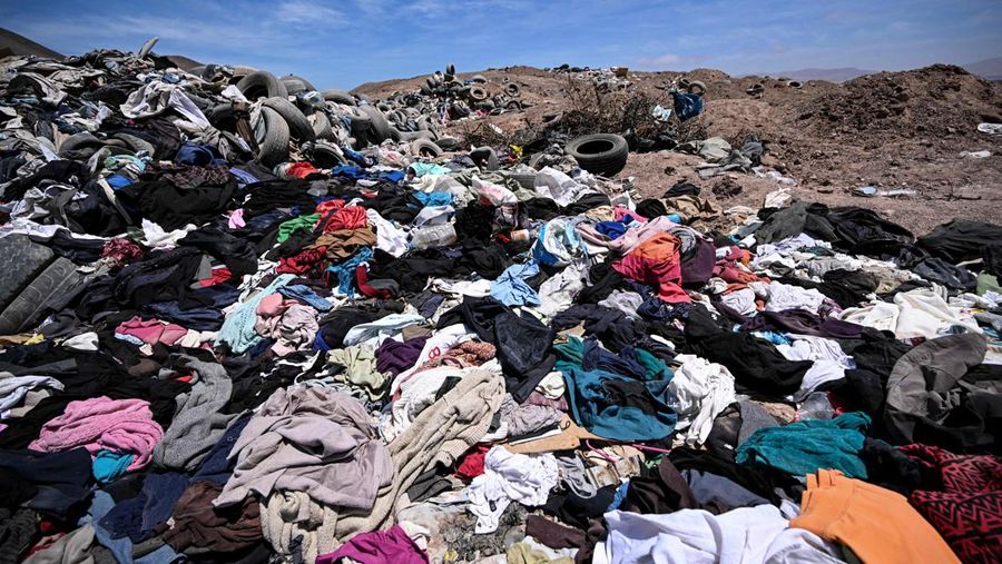 Pengacara Paulina Silva menunjukkan pakaian yang dibuang di padang pasir, di sektor La Pampa di Alto Hospicio, Gurun Atacama, Chili, Sabtu (12/11/2022). Gurun Atacama yang juga merupakan lokasi penelitian ilmiah untuk hidup di Mars merupakan daerah terkering di Bumi terancam oleh tumpukan sampah yang dibuang ke sana dari seluruh dunia. Setiap tahunnya ada lebih dari 46.000 ton sampah dikirim ke gurun pasir yang ada di antara Andes dan rangkaian pengunungan Chili. (Photo by MARTIN BERNETTI / AFP)
