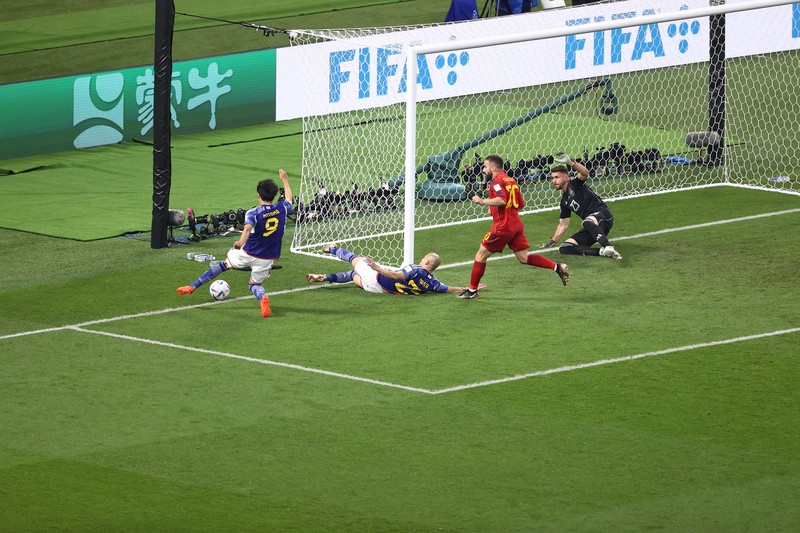 Unai Simon dari Spanyol mengawasi bola saat Kaoru Mitoma dari Jepang menyilangkan bola selama pertandingan Grup E Piala Dunia FIFA 2022 antara Jepang dan Spanyol di Stadion Internasional Khalifa pada 01 Desember 2022 di Doha, Qatar. (Patrick Smith - FIFA/FIFA via Getty Images)