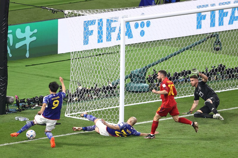 Unai Simon dari Spanyol mengawasi bola saat Kaoru Mitoma dari Jepang menyilangkan bola selama pertandingan Grup E Piala Dunia FIFA 2022 antara Jepang dan Spanyol di Stadion Internasional Khalifa pada 01 Desember 2022 di Doha, Qatar. (Patrick Smith - FIFA/FIFA via Getty Images)