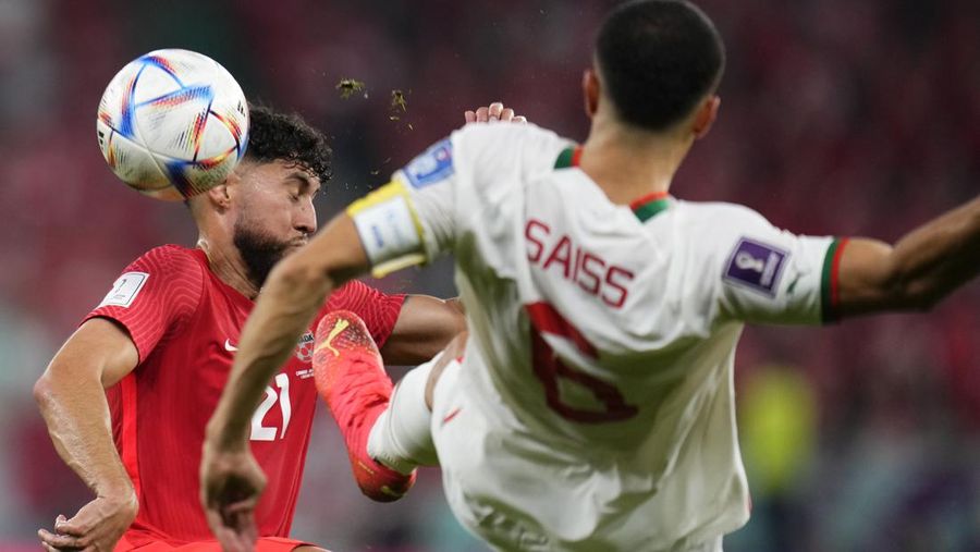Pemain Kanada Jonathan Osorio (kiri) berebut bola dengan pemain Maroko, Romain Saiss selama pertandingan sepak bola grup F Piala Dunia antara Kanada dan Maroko di Stadion Al Thumama di Doha, Qatar, Kamis (1/12/2022). Maroko mengalahkan Kanada 2-1 dalam laga terakhir Grup F Piala Dunia 2022. Hasil ini mengantarkan Singa Atlas melaju ke 16 besar.  (AP Photo/Manu Fernandez)