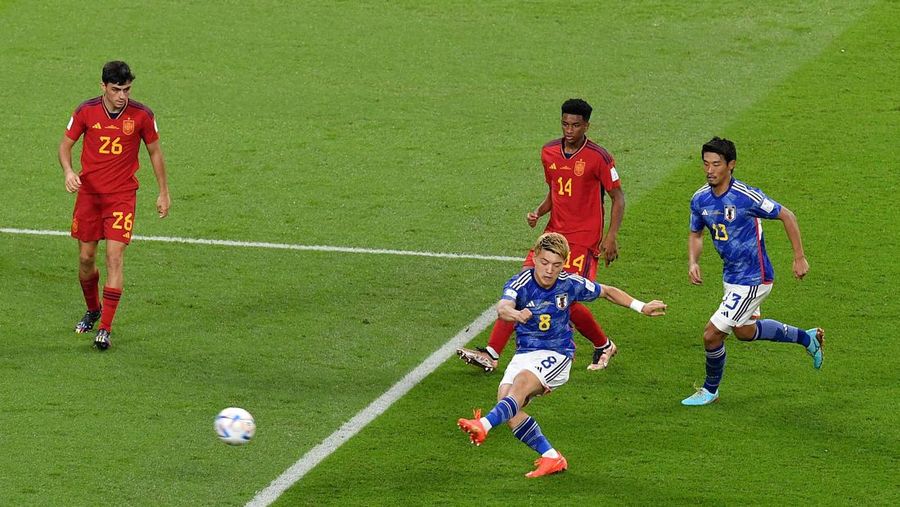 Unai Simon dari Spanyol mengawasi bola saat Kaoru Mitoma dari Jepang menyilangkan bola selama pertandingan Grup E Piala Dunia FIFA 2022 antara Jepang dan Spanyol di Stadion Internasional Khalifa pada 01 Desember 2022 di Doha, Qatar. (Patrick Smith - FIFA/FIFA via Getty Images)