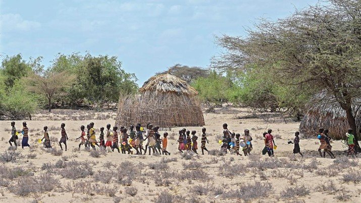 Wilayah Djibouti Anak-anak dari komunitas pastoral Turkana berjalan pada tanggal 18 Oktober 2022 saat mereka menuju untuk menerima jatah makan siang di titik distribusi bantuan makanan terdekat selama klinik penjangkauan komunitas intervensi kekeringan yang diselenggarakan oleh Dana Pendidikan Anak Internasional PBB (UNICEF) di desa Nadoto, di Djibouti. (TONY KARUMBA/AFP via Getty Images)