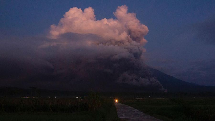 Gunung Semeru memuntahkan asap dan abu di Lumajang pada 4 Desember 2022. (AFP via Getty Images/AGUS HARIANTO)