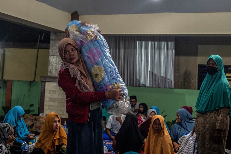 People take temporary shelter in a room at a community hall in Candipuro village following Mount Semeru's volcanic eruption in Lumajang, East Java on December 4, 2022. (Photo by JUNI KRISWANTO / AFP) (Photo by JUNI KRISWANTO/AFP via Getty Images)