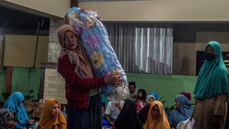 People take temporary shelter in a room at a community hall in Candipuro village following Mount Semeru's volcanic eruption in Lumajang, East Java on December 4, 2022. (Photo by JUNI KRISWANTO / AFP) (Photo by JUNI KRISWANTO/AFP via Getty Images)