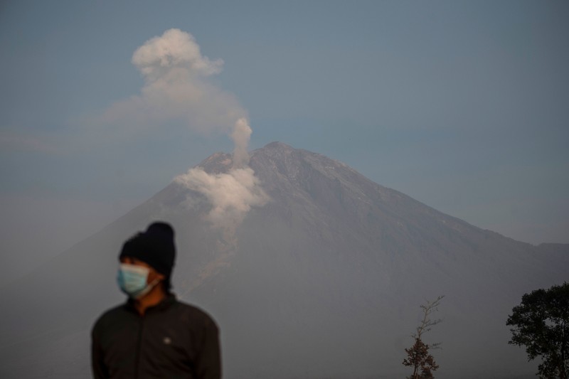 1245371606 Smoke rises from Mount Semeru in Lumajang on December 5, 2022. - Indonesia's Mount Semeru erupted on December 4 spewing hot ash clouds a mile high and rivers of lava down its side while sparking the evacuation of nearly 2,000 people exactly one year after its last major eruption killed dozens. (Photo by JUNI KRISWANTO / AFP) (Photo by JUNI KRISWANTO/AFP via Getty Images)