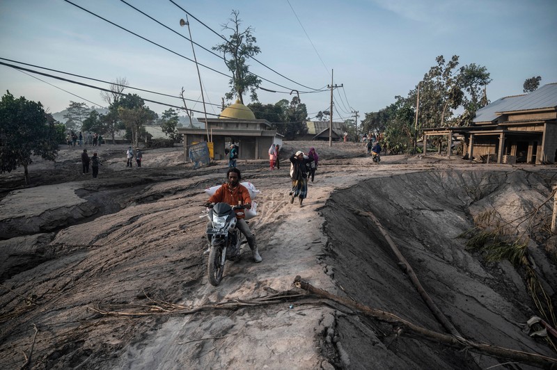 1245371309 LUMAJANG, INDONESIA - DECEMBER 5: Residents are seen rescuing their property and livestock after the eruption of Mount Semeru in Kajar Kuning Village, Lumajang, East Java Province, Indonesia on December 5, 2022. According to data from the East Java Regional Disaster Management Agency, at least 2,219 people fled after the eruption of Mount Semeru that occurred yesterday. (Photo by Suryanto/Anadolu Agency via Getty Images)